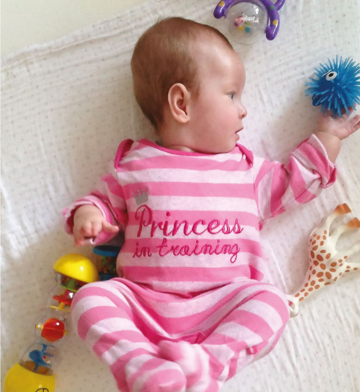 Baby wearing pink stripy baby grow