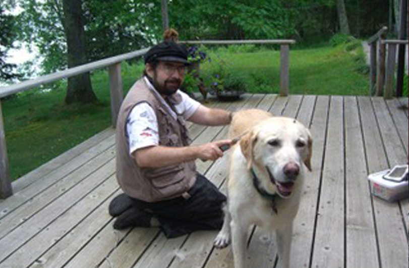 man on wooden decking with dog