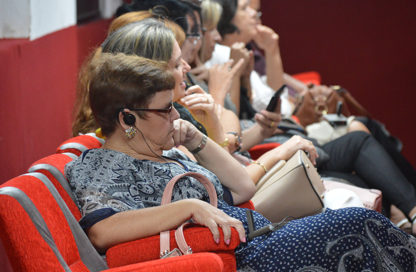 lady with listening device on row of red seats