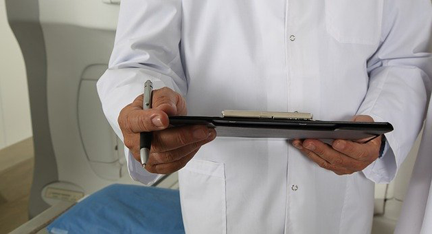 doctor in white coat holding a electronic device