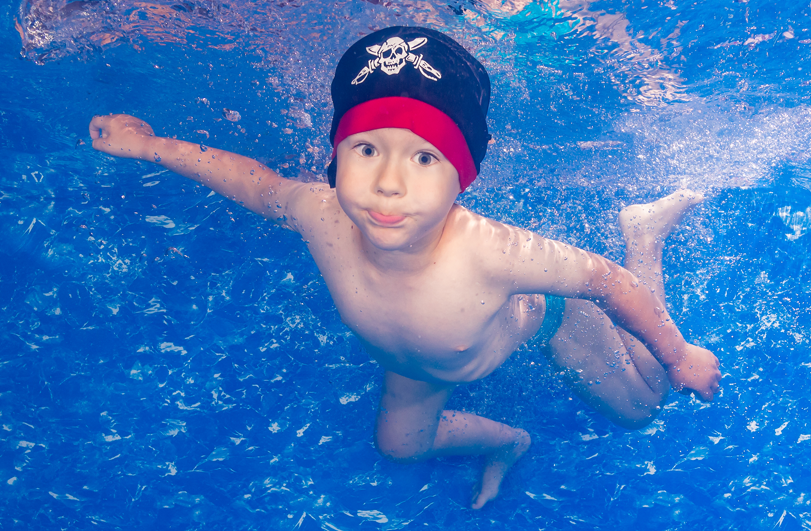 boy swimming underwater in a swimming pool