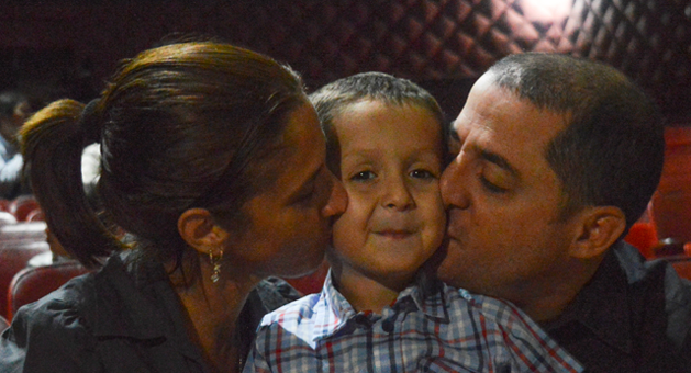 for-families parents kissing a boy on either side of his face