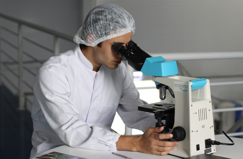 technician looking through microscope